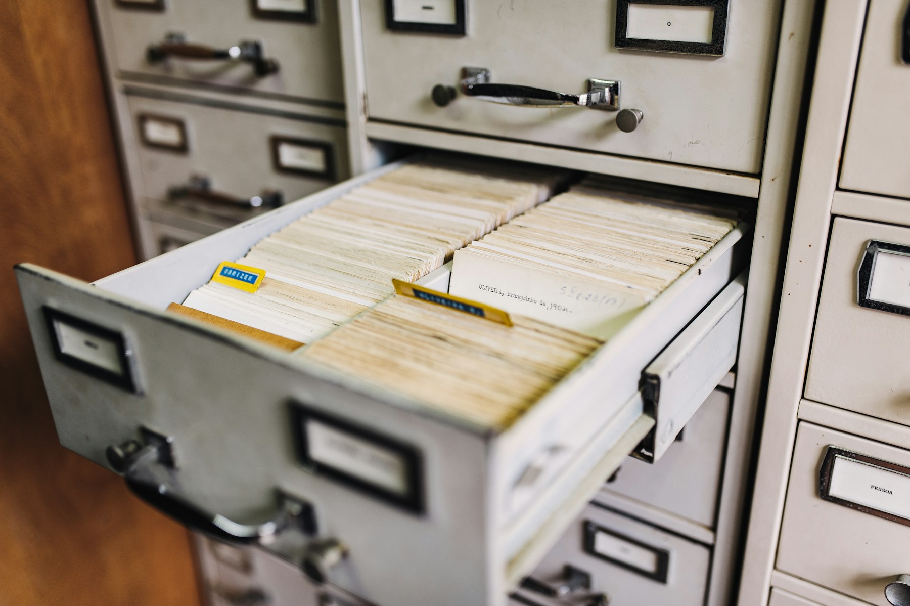 Labelled folders stacked flat in an open drawer
